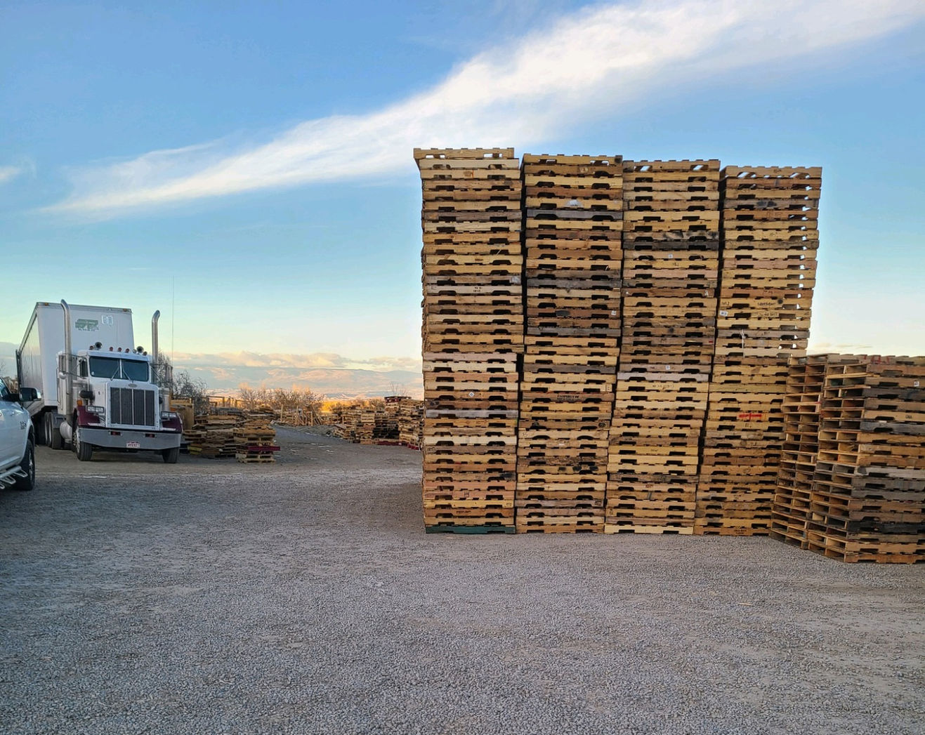 Smith Pallets branded delivery truck loaded with pallets in the yard, mountains in the distance